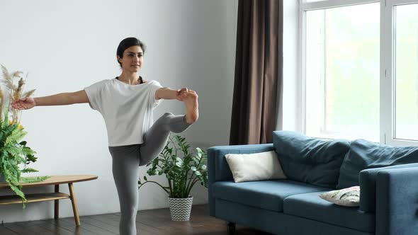 A Young Indian Woman Is Doing Yoga, Doing The Exercise Standing on One Leg For Balance