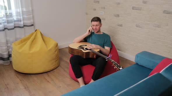 Caucasian Man Is Talking at the Phone with His Guitar Teacher alt