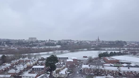 Tracking drone shot of snowy Exeter subburbs looking towards the town centre alt