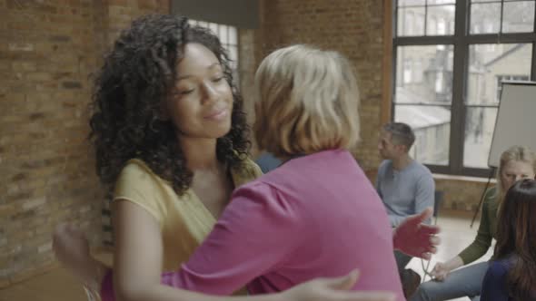 Women hugging in group therapy session