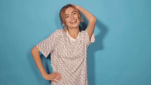 Attractive girl posing in studio near blue wall alt