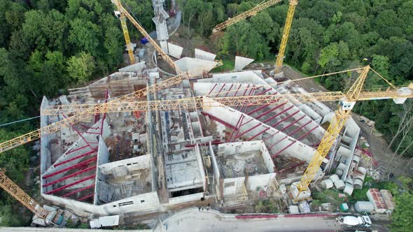 Aerial View Construction of a New Building with High Tower Cranes in Green Area alt