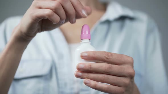 Woman's Hand Holding Nasal Spray and Pressing on It, Healthcare and Medicine alt