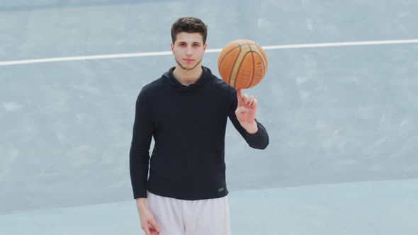 Basketball player spinning the ball on his finger alt