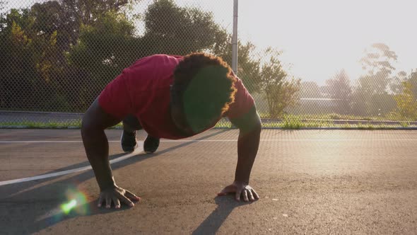 African American man working out by doing burpees alt