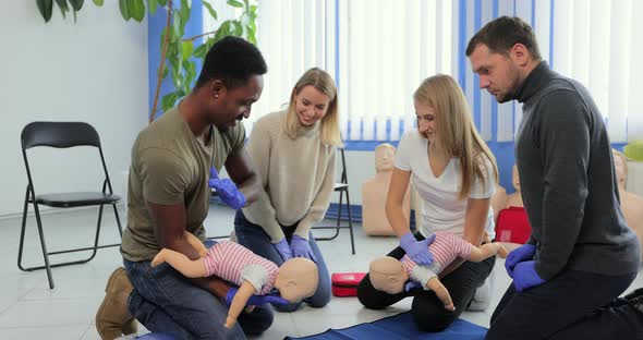 Group of Multiethnic People During the First Aid Training with Instructor Showing on Manikin How to alt
