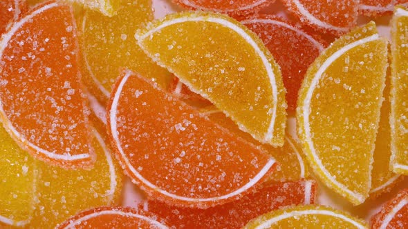 Tasty Orange Gummy Marmalade Fruit Jelly Sprinkled with Sugar Candies Rotate Slowly alt