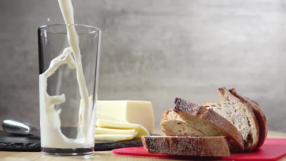 Cheese and Bread and Milk is Poured Into a Glass