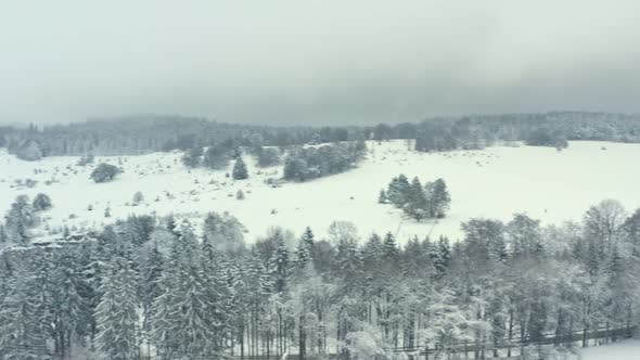 Aerial view over a landscape full of snow. Winterwonderland captured from above with a street, fores alt