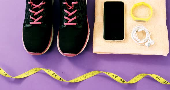 Mobile phone with headphones, shoes, water bottle, fitness band, exercise mat and measuring tape alt