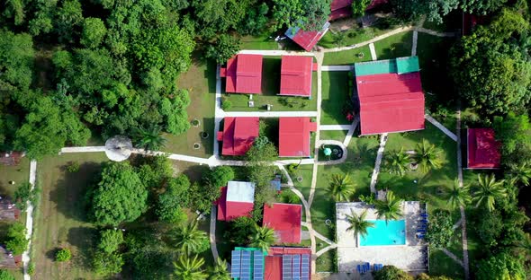 Top down view of red roofs, green landscape and pool of hotel ecologico Loma Pan de Azucar, Monte Pl alt