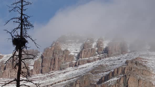 Clouds moving over the snowy cliff face of Hayden Peak alt