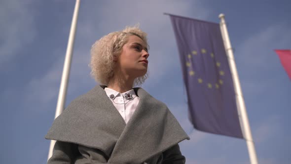 Businesswoman standing near waving flag alt