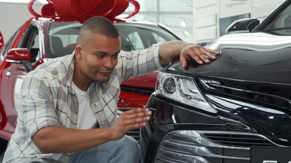 Handsome African Man Showing Thumbs Up While Examining New Car alt