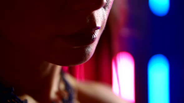 Detail View of Face and Lips of Sexual Woman in Nightclub, Neon Lights Behind Her alt