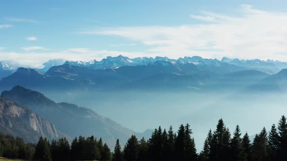 drone view over snow covered mountains during autumn, aerial view over swiss alps with lake fog cove alt
