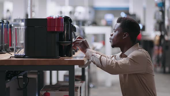 Black Man is Choosing Automatic Coffee Maker in Appliance Store Viewing Exhibition Sample of Modern alt