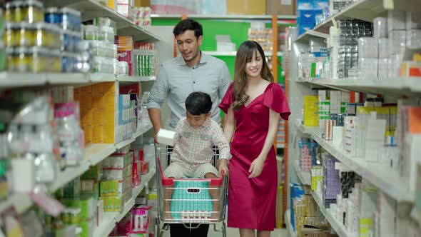 multiracial family consisting of a father Mother and son are using shopping carts in supermarket, th