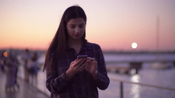 Woman Walking on Street and Using Smartphone Evening Night City Lights