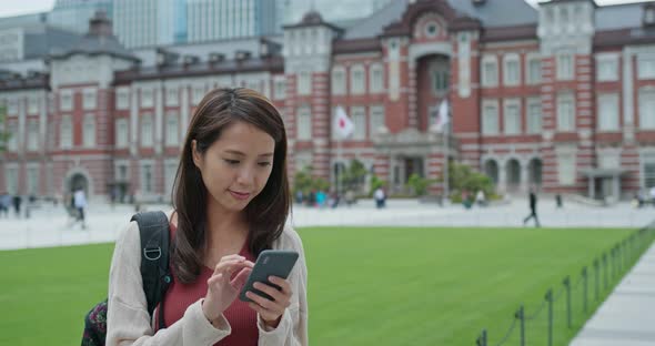 Woman travel in Tokyo and use of mobile phone at Tokyo station alt