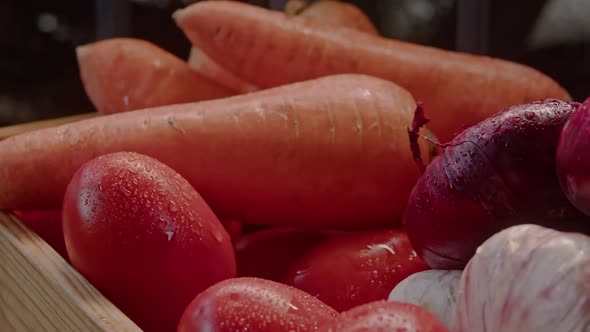 Woman's Hand Takes and Put Back a Tomato From a Box of Vegetables