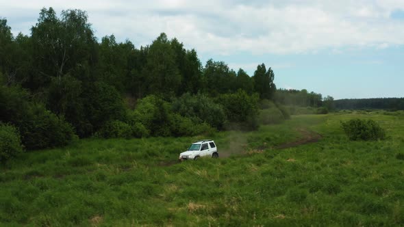 Aerial View of a Car Driving in Nature Near the River alt