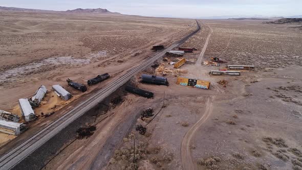 Carnage from a train wreck with debris and cars on both sides of the tracks alt