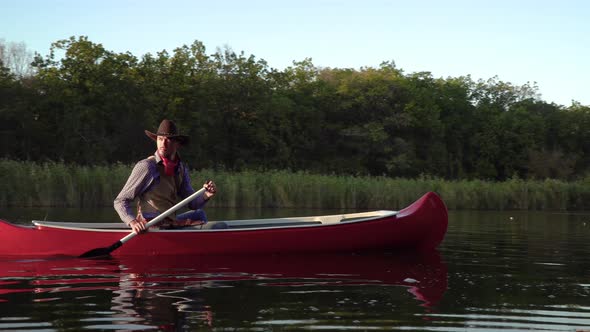 Cowboy in a Canoe Floats on the River alt