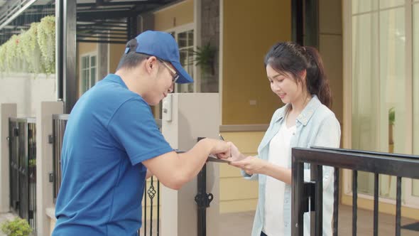 Young postal delivery courier man holding parcel boxes for sending to customer. alt