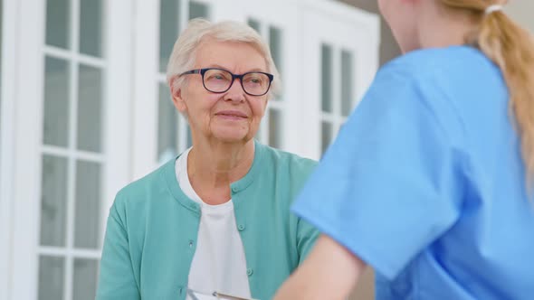 Positive senior lady nods head listening to caregiver recommendations alt