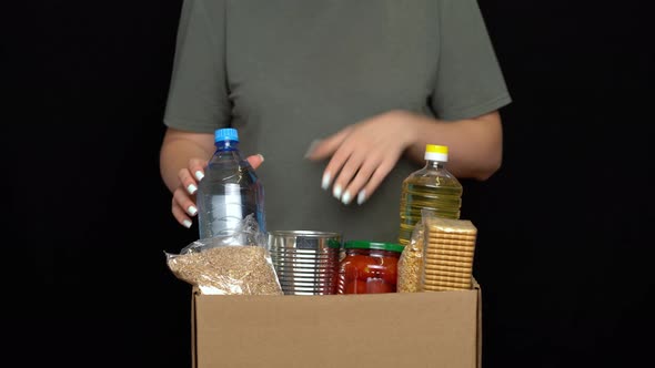 Volunteer Putting Food in a Donation Box. Charity Concept alt