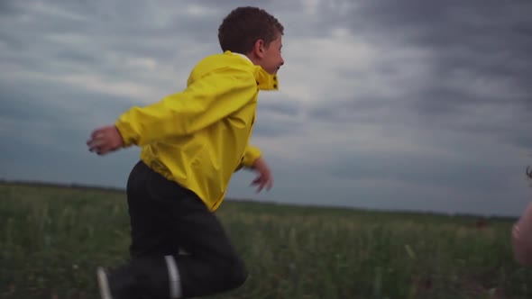 Caucasian Boy Trying to Catch Up Little Pretty Girl Running on Grass Outside Slomo alt