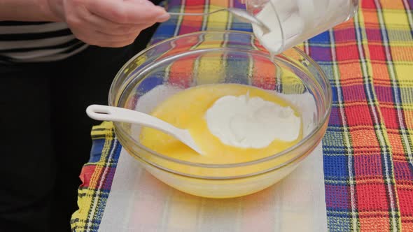 Senior Caucasian Woman Adding Sour Cream to the Bowl with Liquid Sweet Dough