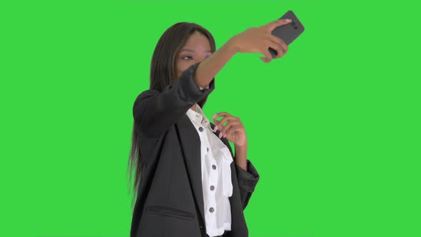 Pretty African Amerivan Female Making Selfie on Her Phone on a Green Screen, Chroma Key. alt