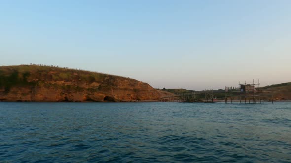 Amazing low angle water surface pov of Trabocco or trebuchet at Punta Aderci Abruzzo natural reserve alt
