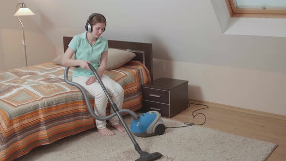 Cute Caucasian girl cleaning her house with sadness. alt