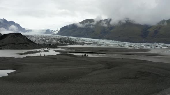 Tourists Hike Near The Skaftafellsjokull Glacier In Southeast Iceland. - aerial forward alt