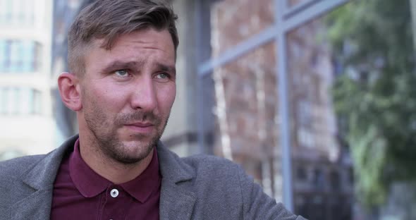 Portrait of Serious Sad Man Looking Into the Distance Outdoors alt