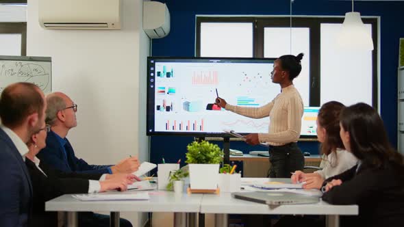 Black Analyst Using Digital Interactive Whiteboard for Presentation alt