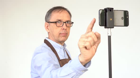 An Elderly Male Blogger Prepares to Start Broadcasting alt