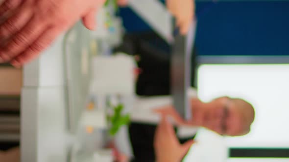 Close Up of Multiracial Business Partners Standing in Front of Conference Desk Shaking Hands alt