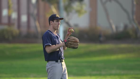 A young man playing catch with a baseball. alt