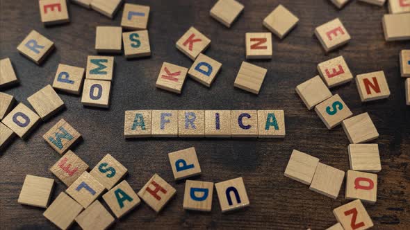 AFRICA Made of Wooden Letters Vocabulary Game Zoom in Brown Wooden Table Background alt