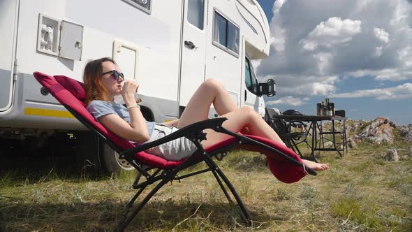 Camper Rv Woman Sitting On Folding Chair and Drinking Juice