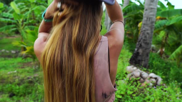 Beautiful redhead walking through jungle forest, back view close up alt