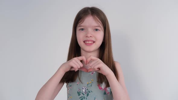Little Girl Makes a Heart with Her Hands