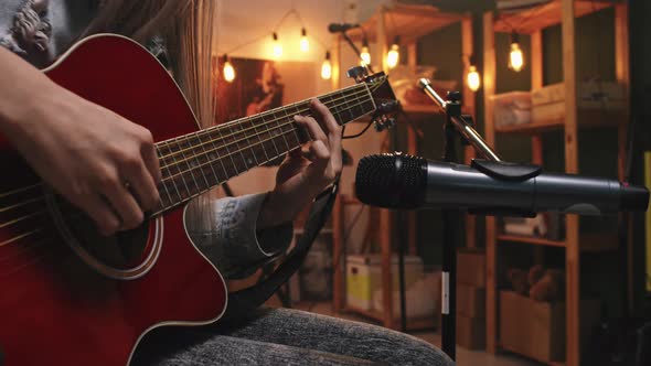Female Guitarist Playing To Mic In Studio alt