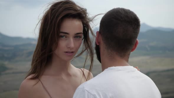 Beautiful Young Girl Hugs Boyfriend and Looks Into the Camera