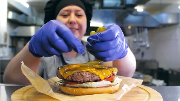 Female Chef Is Preparing a Delicious Burger with Cheese at Restaurant Kitchen