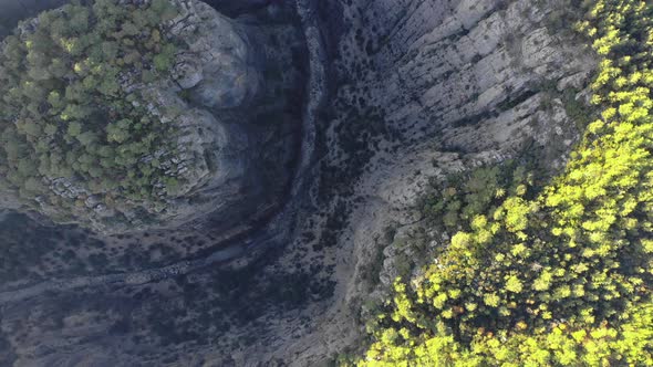 Aerial view of a water dam, reservoir lake and mountains covered with greenery, trees